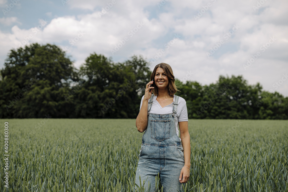 Young woman on the phone in a grain field in the countryside Young woman on the phone in a grain field in the countryside