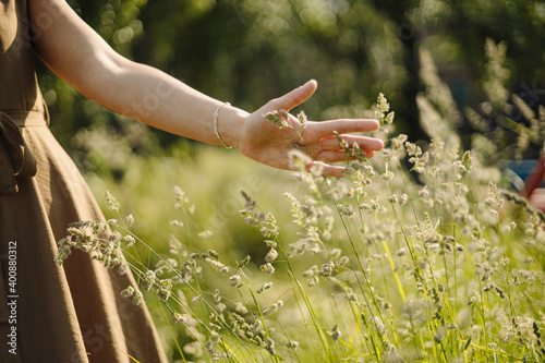 Close-up of woman touching grass in the countryside
