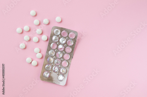 Tablets in a package and without on a pink background. Flat lay.