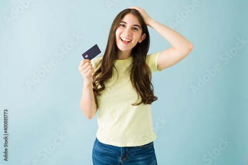 Portrait of an excited young woman holding up her credit card