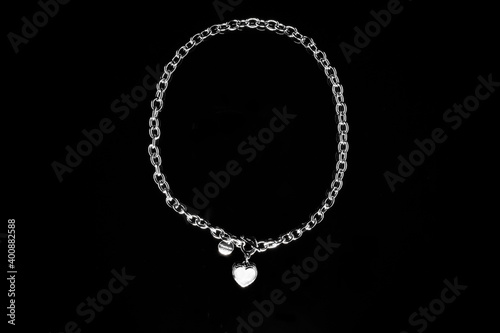 Silver jewelry chain with medallion isolated on black background