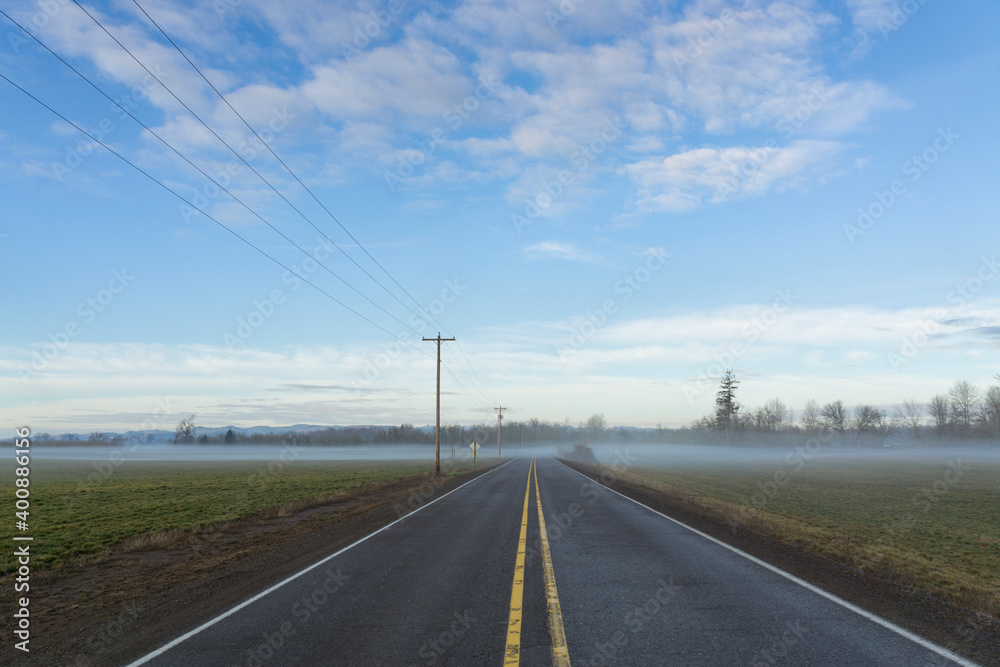 Highway going through plain covered with fog Highway going through plain covered with fog