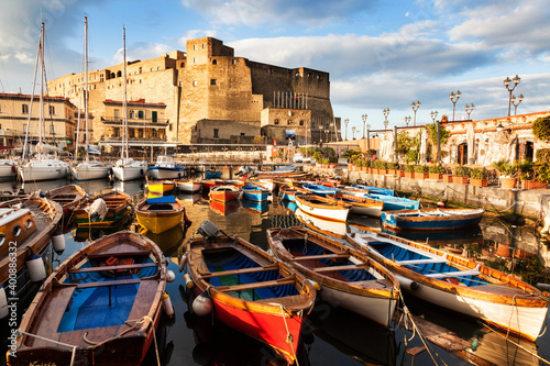 Colorful boats and Castel dell' Ovo at night photo