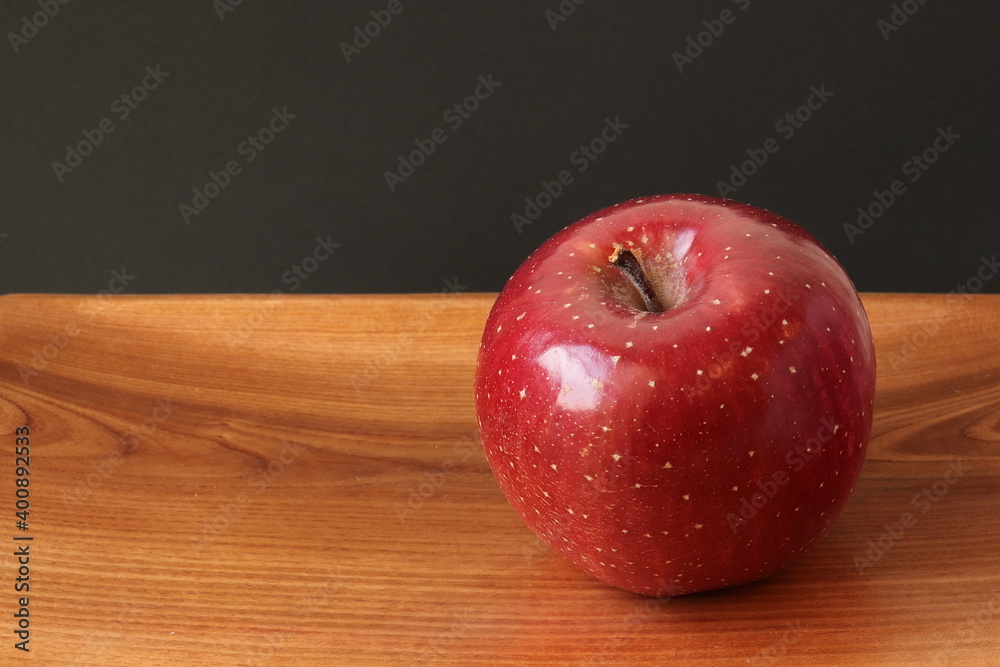 Fuji apple on a wooden plate, isolated Fuji apple on a wooden plate, isolated