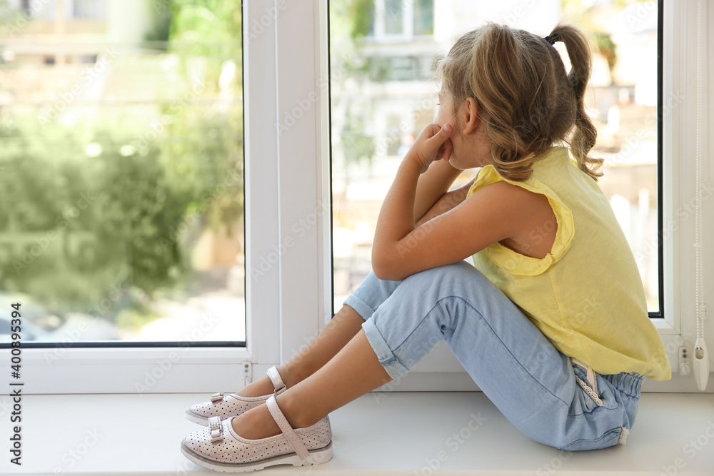 Cute little girl on window sill at home Cute little girl on window sill at home