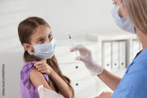 Doctor vaccinating little girl in hospital. Health care