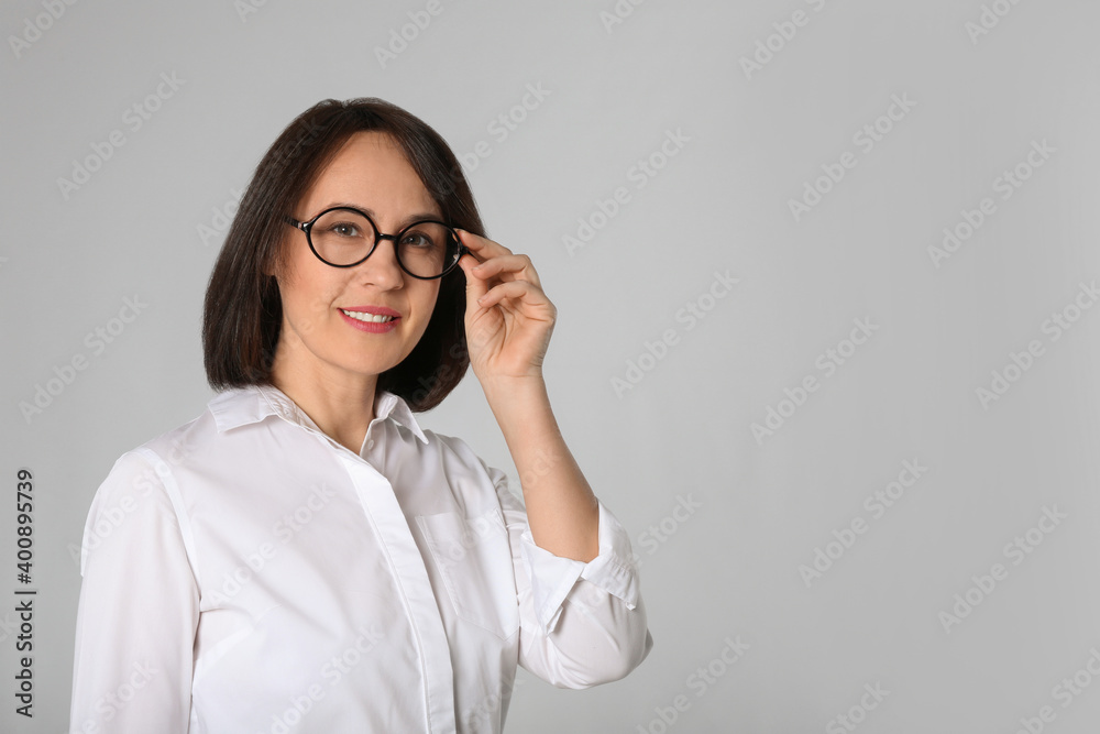 Portrait of mature businesswoman on light grey background. Space for text Portrait of mature businesswoman on light grey background. Space for text