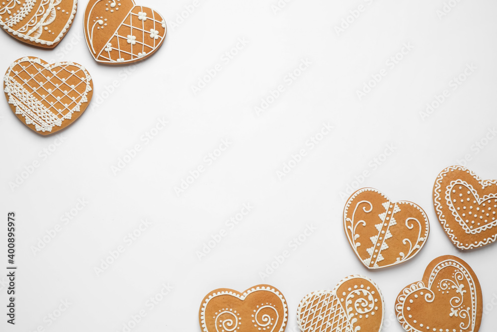 Gingerbread hearts decorated with icing on white background, flat lay. Space for text