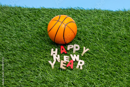 Basketball for Happy New Year with ball and letter on green grass