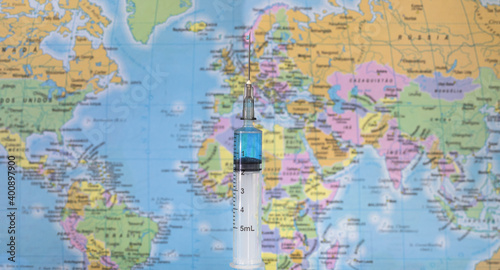 Seringa de vacina e mapa mundi desfocado photo
