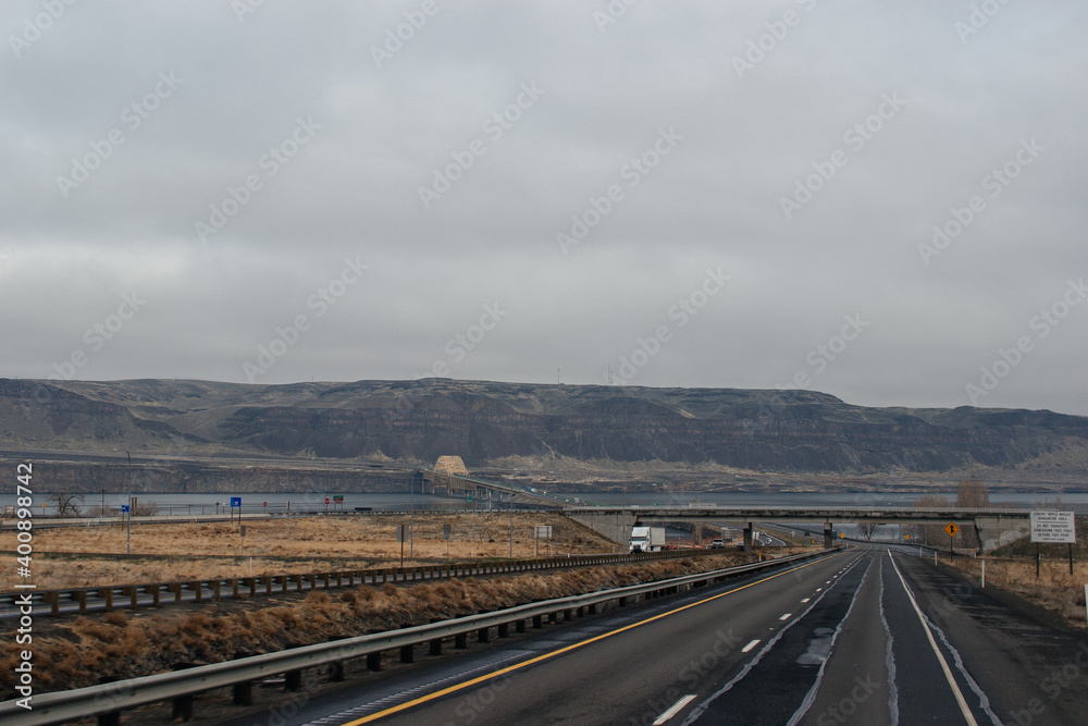Autumn highway with trucks and cars among the mountains, bridge, road signs on a cloudy day. Oregon, USA, 02-07-2020 Autumn highway with trucks and cars among the mountains, bridge, road signs on a cloudy day. Oregon, USA, 02-07-2020