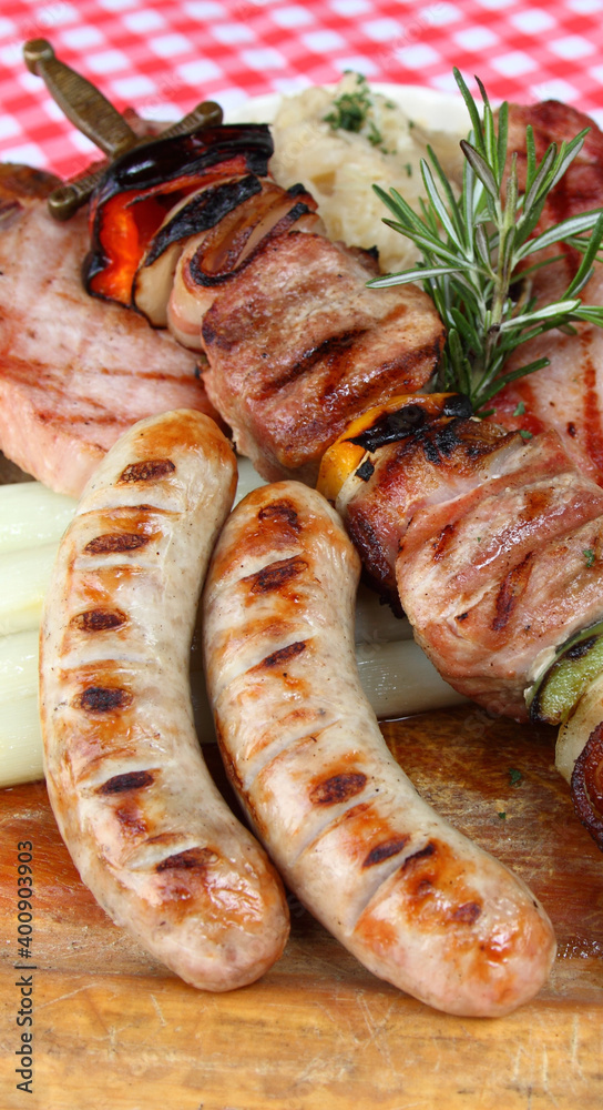 German mixed grill platter with sausages, pork chops, skewers, sauerkraut, asparagus, red cabbage, bread dumpling and wild garlic spätzle German mixed grill platter with sausages, pork chops, skewers, sauerkraut, asparagus, red cabbage, bread dumpling and wild garlic spätzle