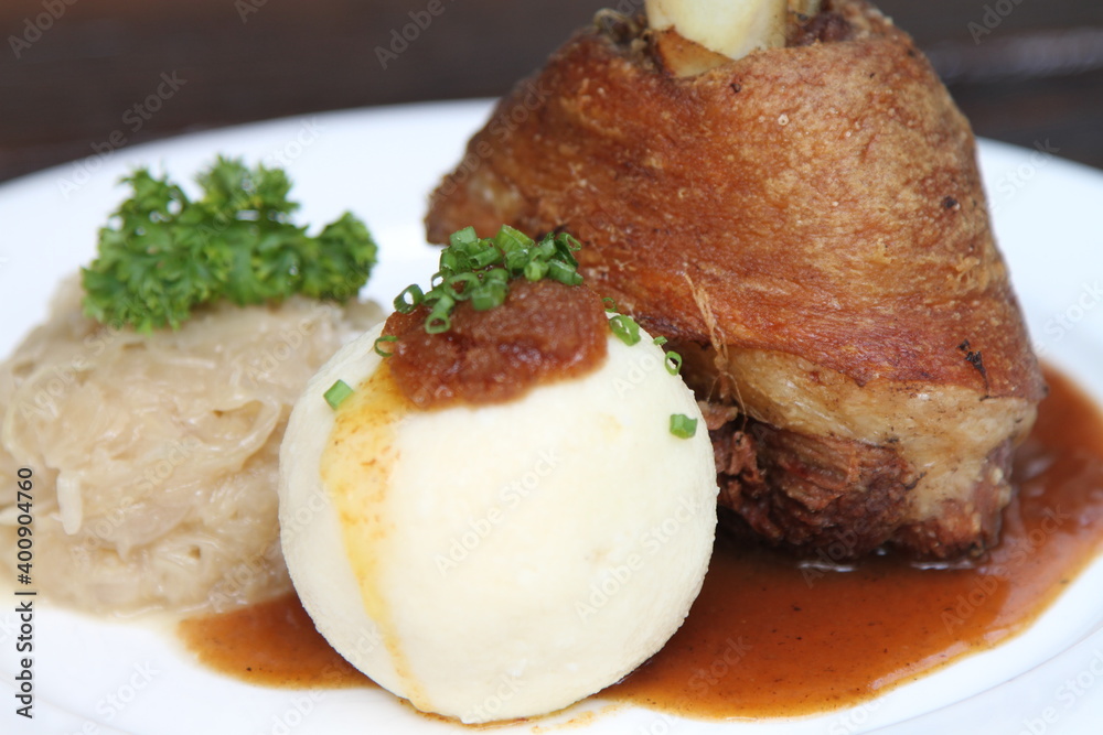 Bavarian pork knuckle with potato dumpling and sauerkraut on gravy Bavarian pork knuckle with potato dumpling and sauerkraut on gravy