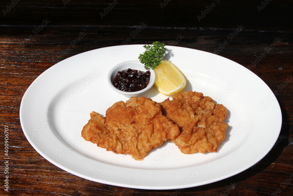 Pork Schnitzel Vienna style served with cranberry jam and lemon. Bread