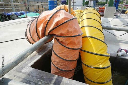 Flexible air duct for ventilation from confined spaces in the construction of large chemical storage tanks.
