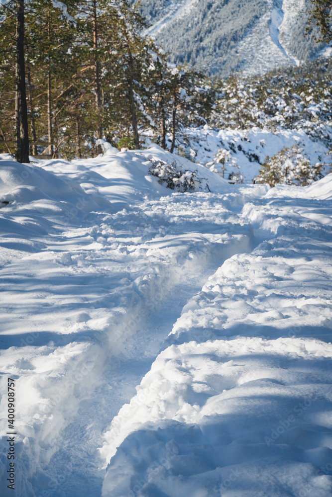 Small winter walking path through deep snow in Austrian Alps at Mieming, Tyrol, Austria Small winter walking path through deep snow in Austrian Alps at Mieming, Tyrol, Austria