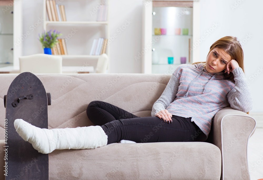 Obraz premium Young woman with broken leg at home