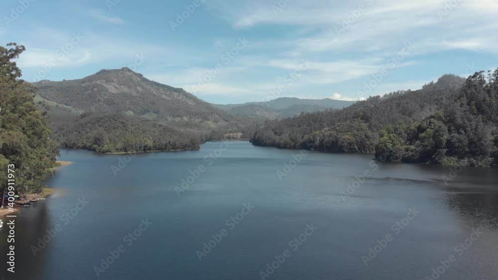 Mattupetty in Munnar, surrounded by lush mountains and hills in India - Aerial Low angle Fly-over shot Mattupetty in Munnar, surrounded by lush mountains and hills in India - Aerial Low angle Fly-over shot