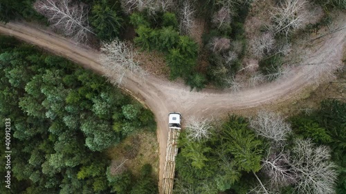 Descending drone view of truck loaded with logs in forest. photo