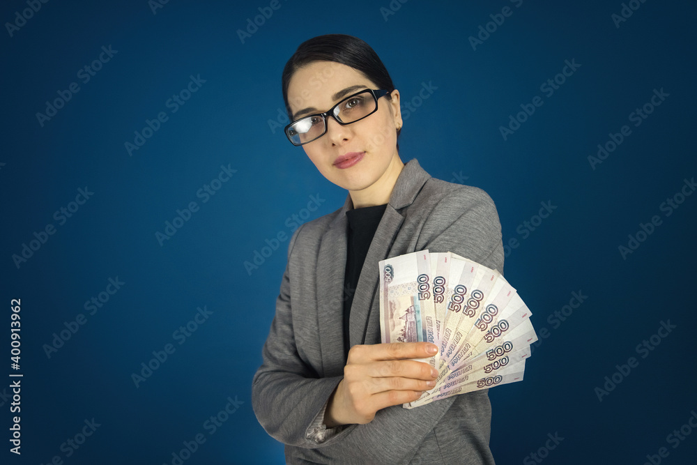 Beautiful young woman in glasses holds a lot of Russian rubles in her hands. Beautiful young woman in glasses holds a lot of Russian rubles in her hands.