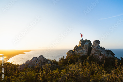 Lone man standing on the top of East Mount Barren as the sun rises behind him. Located in the Fitzgerald River National Park in Hopetoun, Western Australia. 