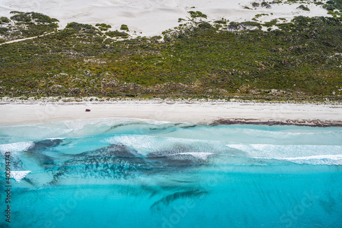 Car driving along a perfect beach in Esperance. 