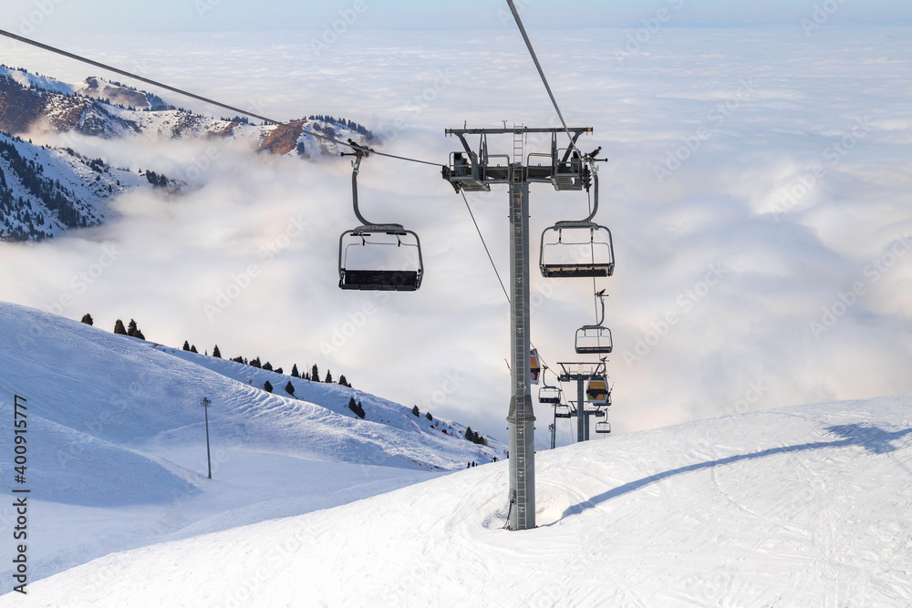Winter mountains panorama with ski slopes and ski lifts near Almaty city. Winter vacation concept Winter mountains panorama with ski slopes and ski lifts near Almaty city. Winter vacation concept