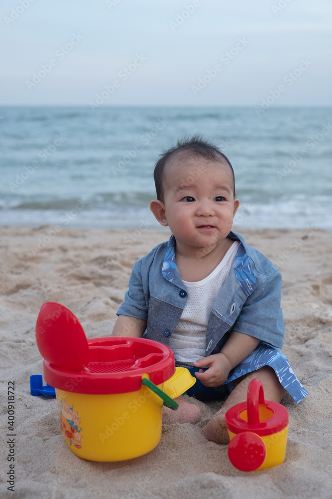 Adorable Cute Asian baby boy playing with beach toys on tropical beach Adorable Cute Asian baby boy playing with beach toys on tropical beach
