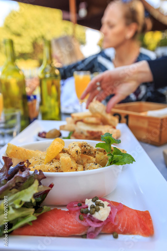 Delicious platters of food with seafood, cured meats and cheeses on wooden serving boards with community eating shared food