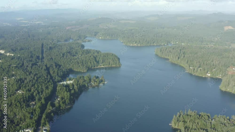 Aerial of lush forest surrounding a deep blue lake Aerial of lush forest surrounding a deep blue lake