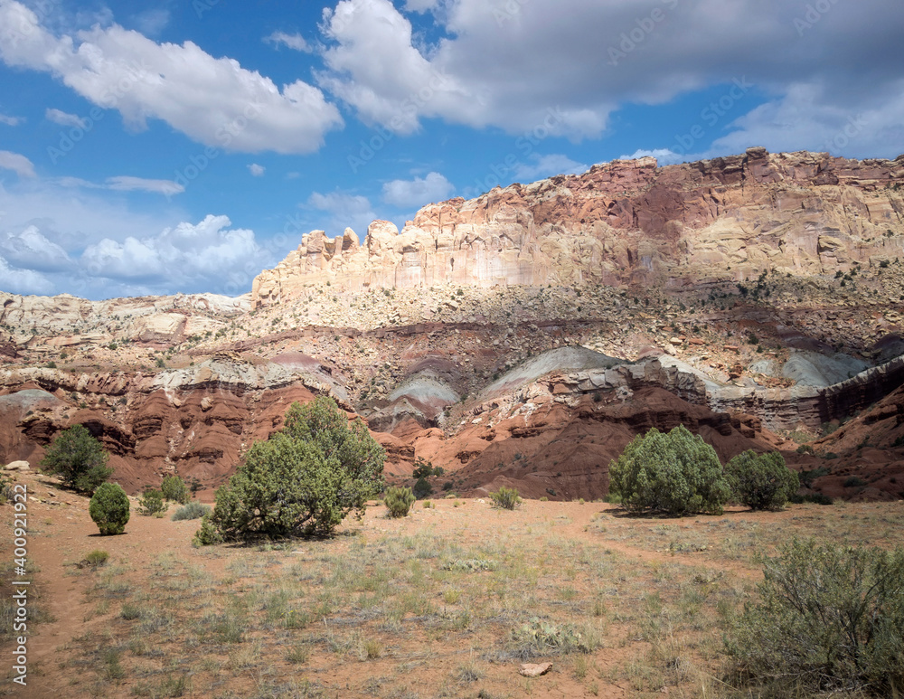 Unbelievable sandstone cliff and superlative domes with tumbleweeds on a hot summer partly cloudy day in Capitol Reef National Park in Southern Utah Unbelievable sandstone cliff and superlative domes with tumbleweeds on a hot summer partly cloudy day in Capitol Reef National Park in Southern Utah