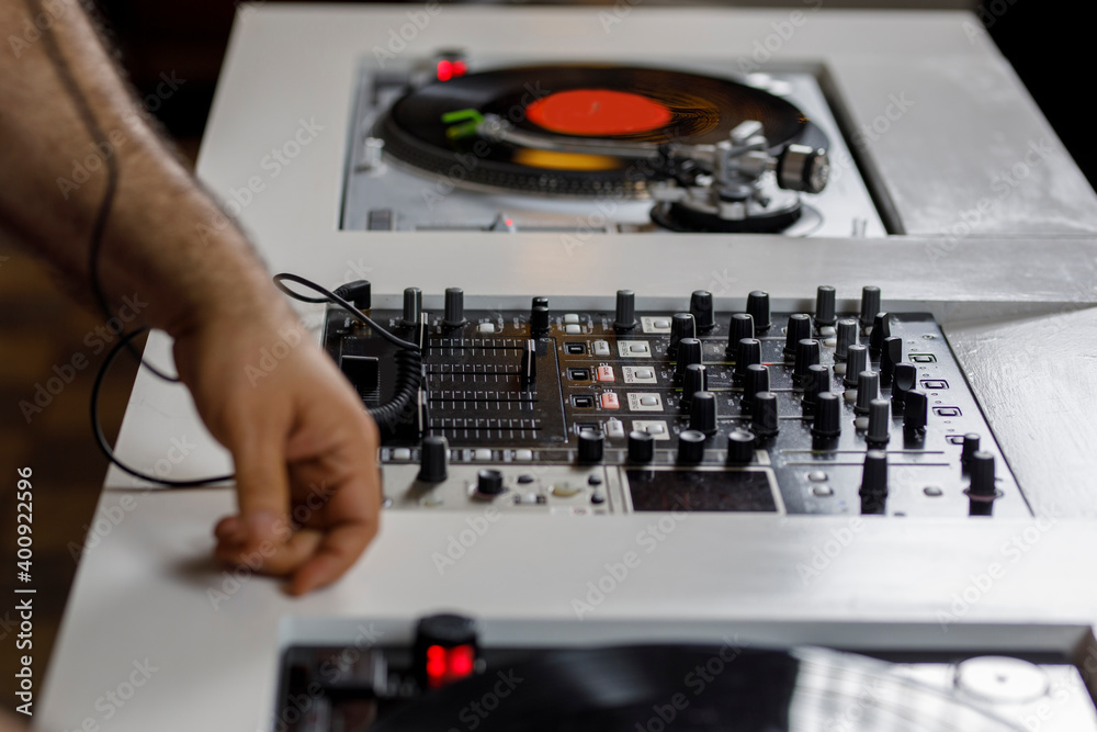 Mesa de Dj con un tocadiscos que tiene un disco de vinil rosa y unos audífonos al costado. Concepto de música retro Mesa de Dj con un tocadiscos que tiene un disco de vinil rosa y unos audífonos al costado. Concepto de música retro