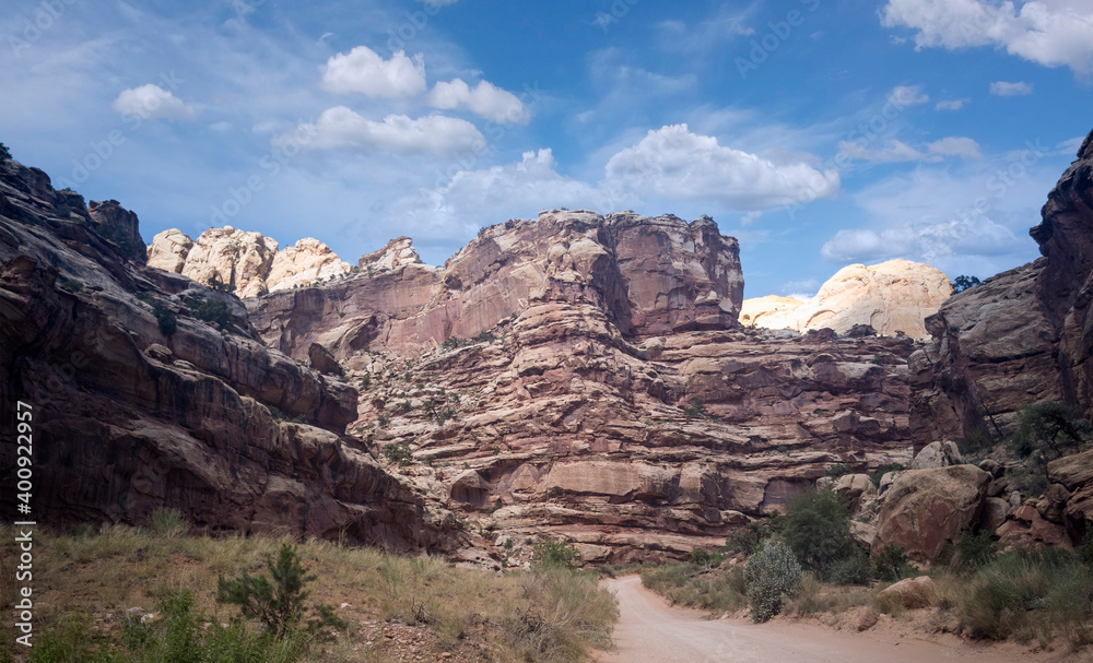 Unbelievable sandstone cliff and superlative domes with tumbleweeds on a hot summer partly cloudy day in Capitol Reef National Park in Southern Utah