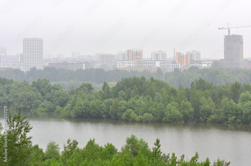 New multi-storey residential buildings of modern architecture in the fog on the banks of the Ob river in Novosibirsk