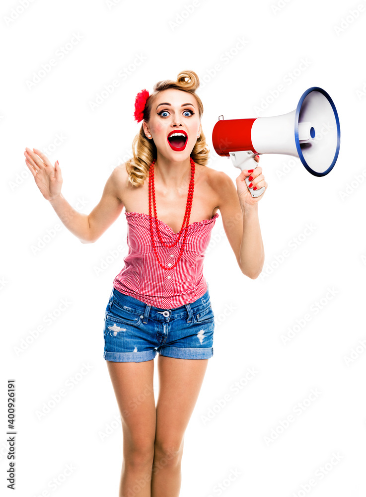 Naklejka premium Happy excited, surprised woman holding megaphone and shout. Girl in pin up style, with open mouth in retro vintage studio concept, isolated against white background.