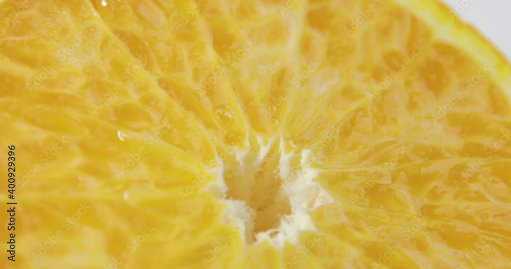Background with orange. Half of juicy orange is slowly rotating on white background, closeup view. Healthy organic product for vegetarian diet. Background with orange. Half of juicy orange is slowly rotating on white background, closeup view. Healthy organic product for vegetarian diet.
