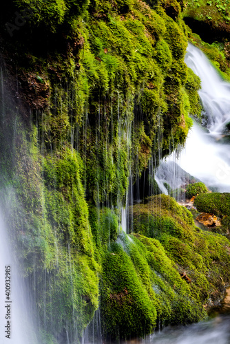 Ecology and nature. The source of clean drinking spring water among stone rocks and moist fresh green moss