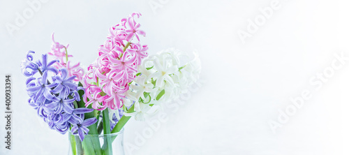 Spring floral background. Purple, pink, white hyacinth flowers bouquet on shelf in front of stone wall. Copy space