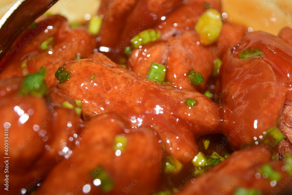 Crispy sausages mixed with tomato sauce, scallions, vegetables and spices, sweet and fragrant, a snack for children or families.