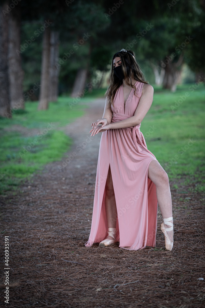 Teenage woman dancing ballet outdoors wearing protective face mask for protection from  Covid-19 Pandemic