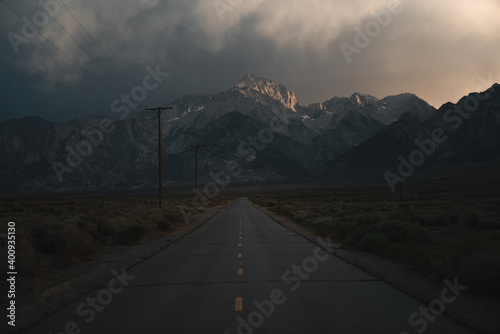Road leading into dramatic mountains at sunset