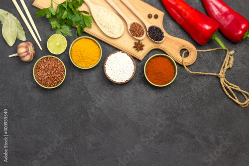 Different types of rice and spices. Wooden cutting board. Raw Red Pepper