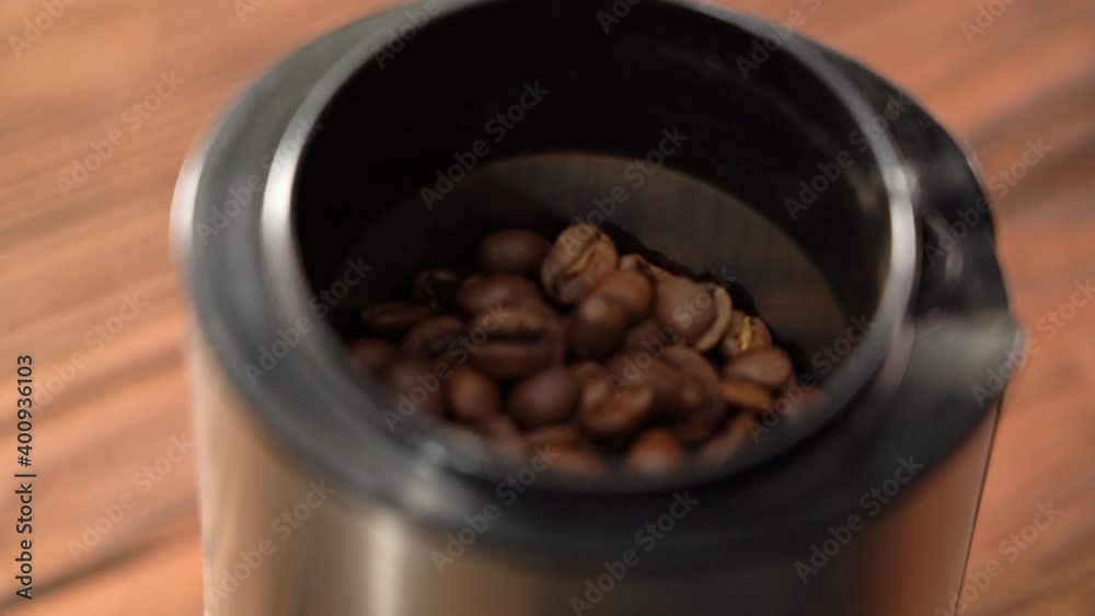 Pour coffee beans into the grinder. Macro video of how coffee beans are pouring onto the blade of an electric coffee grinder. The concept of barista working and making quality coffee. Pour coffee beans into the grinder. Macro video of how coffee beans are pouring onto the blade of an electric coffee grinder. The concept of barista working and making quality coffee.