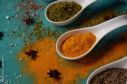 Fototapeta Naklejka Na Ścianę i Meble -  Various colorful herbs and spices for cooking in spoons. Pepper, chili, paprika, basil, turmeric.
