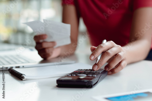 Businessman hand holding pen and press calculator to calculate tax document, finance report. Business office concept.