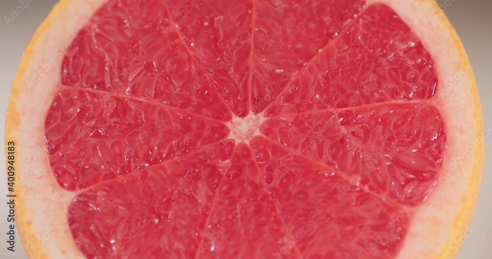 Grapefruit cut in half with drops of water, juice on fruit flesh. Macro shot