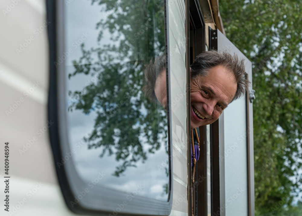 Man is looking from door of the caravan. Man is looking from door of the caravan.