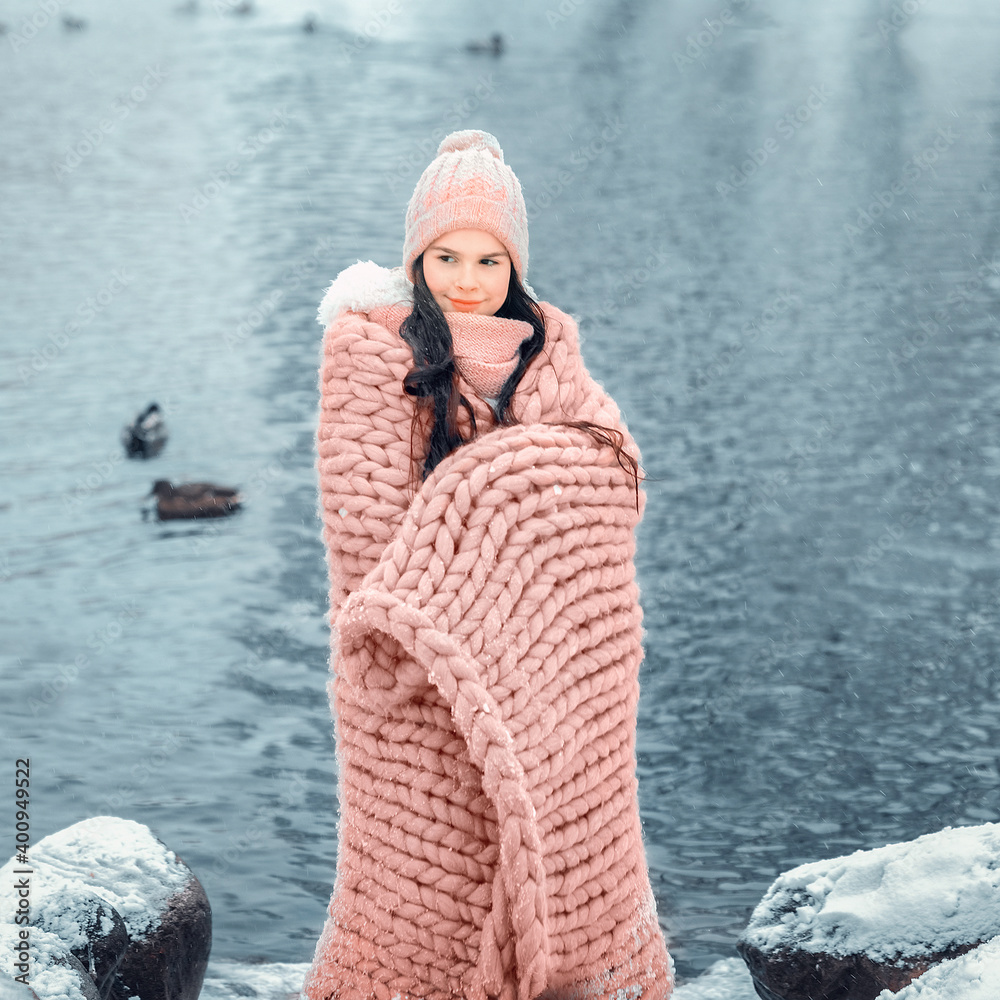 Little girl wrapped in warm plaid by winter at lake. Image with selective focus, toning and noise Little girl wrapped in warm plaid by winter at lake. Image with selective focus, toning and noise