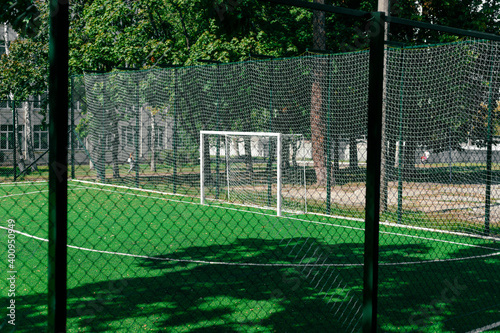 Soccer field behind the iron fence. School soccer stadium