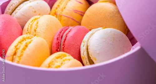 Colorful french cookies macarons set in pink gift box. Tasty fruit, almond sweet cookies, cake macaron